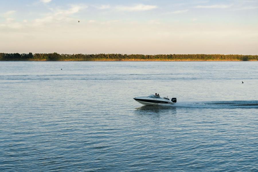 Boat cruising Bass Lake at sunset