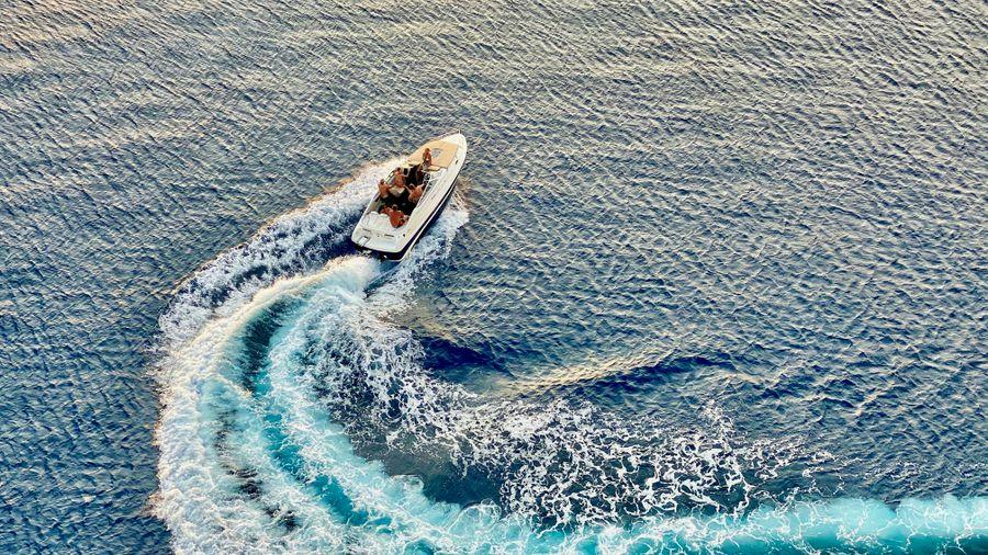 Polished hull cutting through clear lake water